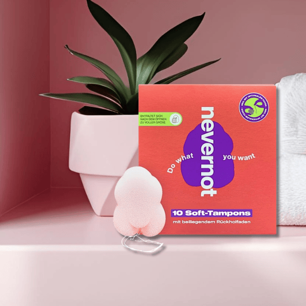 Die Softtampons von NeverNot stehen neben einem Blumentopf auf dem Regal im rosa Zimmer – dezent platziert, diskret, modern und einsatzbereit.