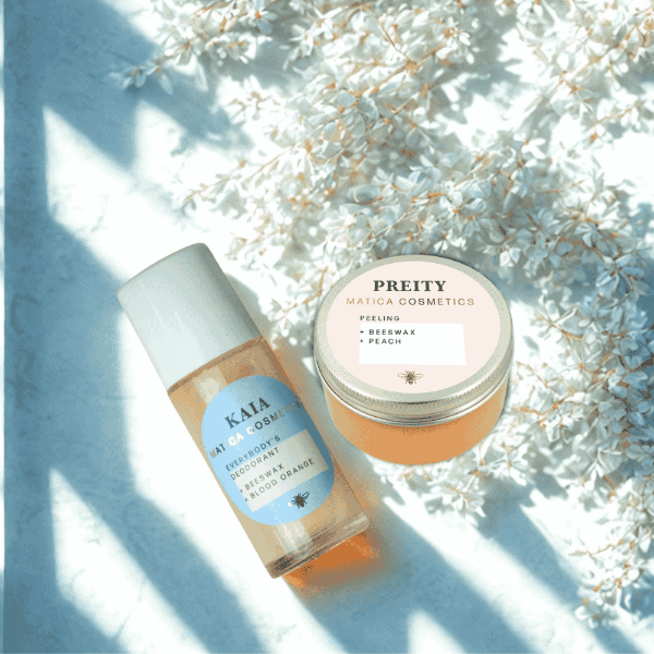 Kaia Deo-Roller und Preity Peeling vor floralem Hintergrund – sanfte Pflege und frische Vibes, eingerahmt von zarten Blüten in natürlichen Tönen.